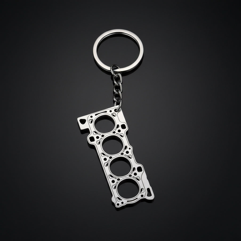 Metallic keychain shaped like a car engine block on a black background